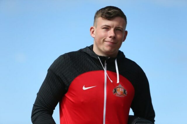 Anthony Patterson fotografado sorrindo para a câmera enquanto usava uma blusa do Sunderland