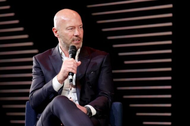 Alan Shearer fotografado falando em um evento da Premier League com um microfone na mão