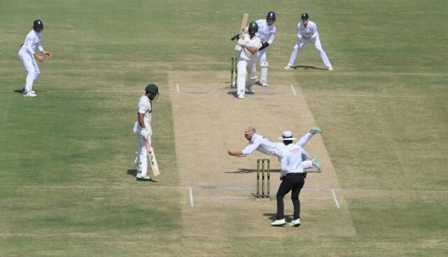 MULTAN, PAQUISTÃO - 11 DE OUTUBRO: O jogador de boliche inglês Jack Leach mergulha para pegar o batedor paquistanês Shaheen Shah Afridi em seu próprio boliche durante o quinto dia da primeira partida de teste entre Paquistão e Inglaterra no Multan Cricket Stadium em 11 de outubro de 2024 em Multan, Paquistão. (Foto de Stu Forster/Getty Images)