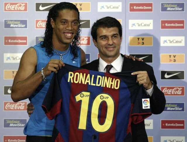 Ronaldinho, o novo astro do futebol brasileiro do Barcelona, ​​e o recém-eleito presidente do Barcelona, ​​Joan Laporta, seguram a camisa de Ronaldinho durante sua apresentação oficial no Estádio Camp Nou