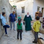 Musa Baghdadi e Warda Yunis com seus quatro netos, tendo finalmente chegado à sua antiga casa na cidade de Al-Bara, Idlib (Ali Haj Suleiman/Al Jazeera)