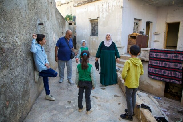 Musa Baghdadi e Warda Yunis com seus quatro netos, tendo finalmente chegado à sua antiga casa na cidade de Al-Bara, Idlib (Ali Haj Suleiman/Al Jazeera)