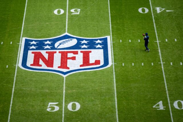 Um jogador se aquece próximo ao logotipo da NFL pintado em campo antes da partida da NFL entre Seattle Seahawks e Tampa Bay Buccaneers na Allianz Arena em 13 de novembro de 2022 em Munique, Alemanha.