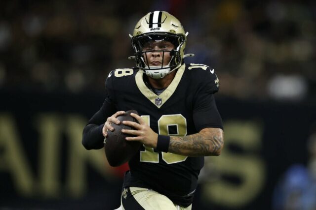 NOVA ORLEÃES, LOUISIANA - 25 DE AGOSTO: Spencer Rattler # 18 do New Orleans Saints corre com a bola contra o Tennessee Titans no Mercedes Benz Superdome em 25 de agosto de 2024 em Nova Orleans, Louisiana. 