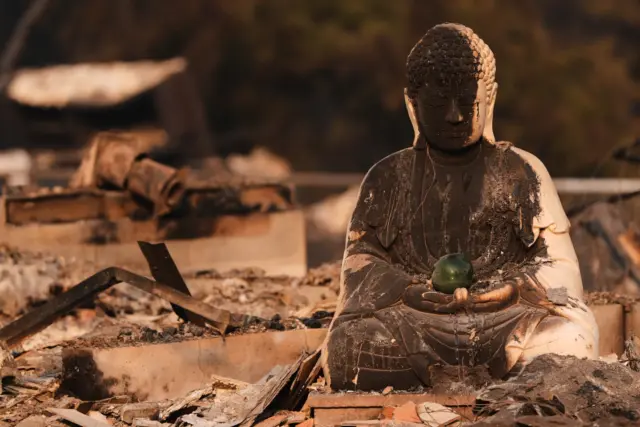 A Buddha statue is seen with fire damage